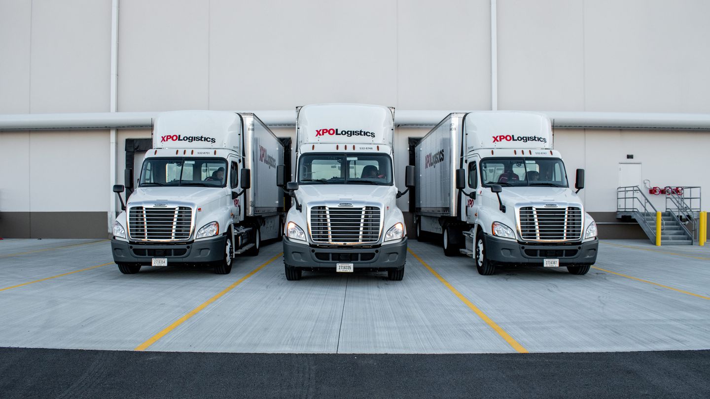 Three XPO trucks at a service center